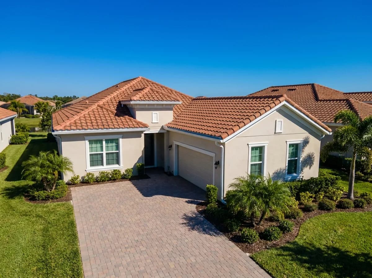 The same South Florida home photographed in intact condition before the storm, with a complete tile roof.